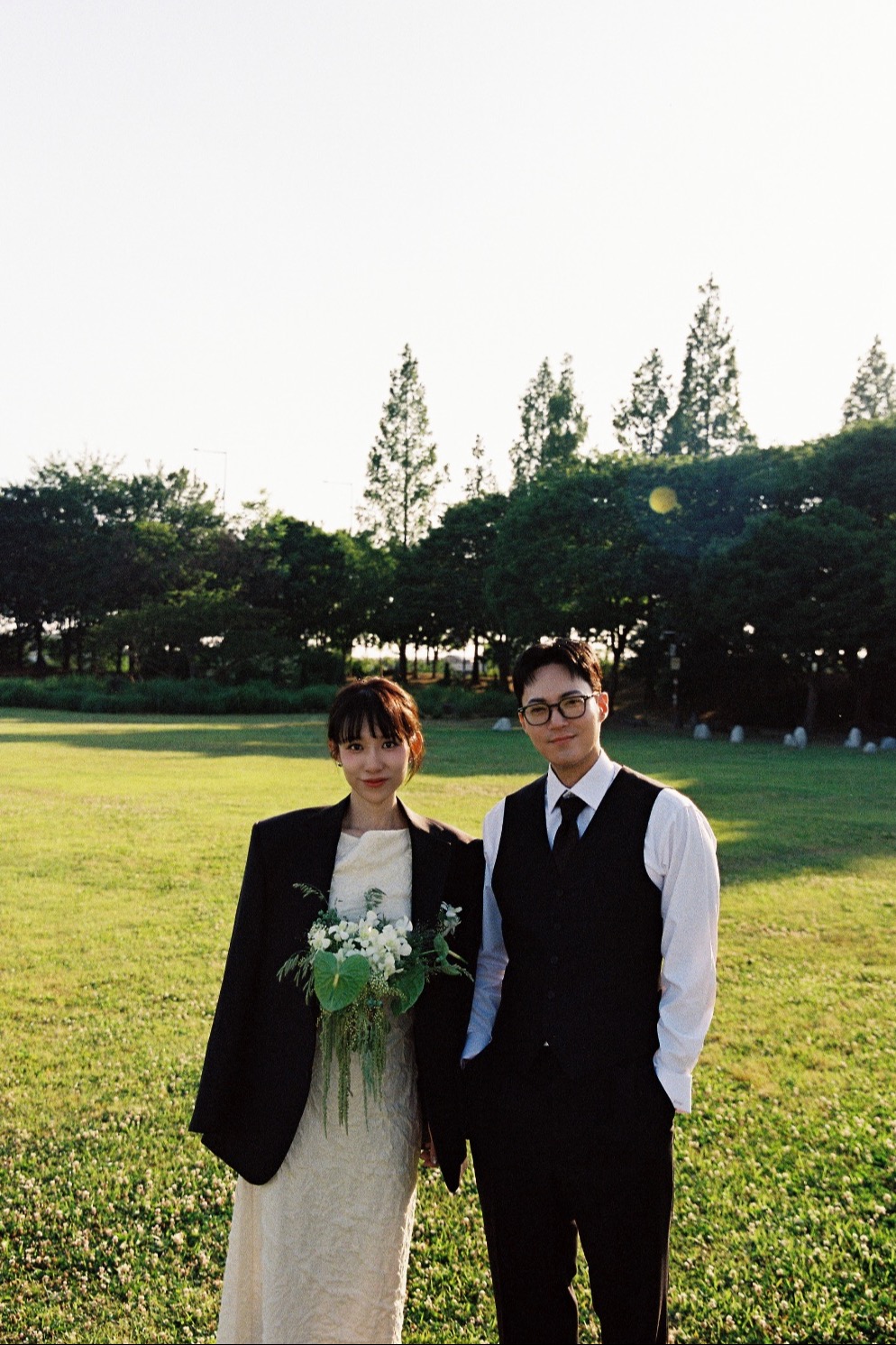 Yongjun and Jinhee together in a sunlit garden